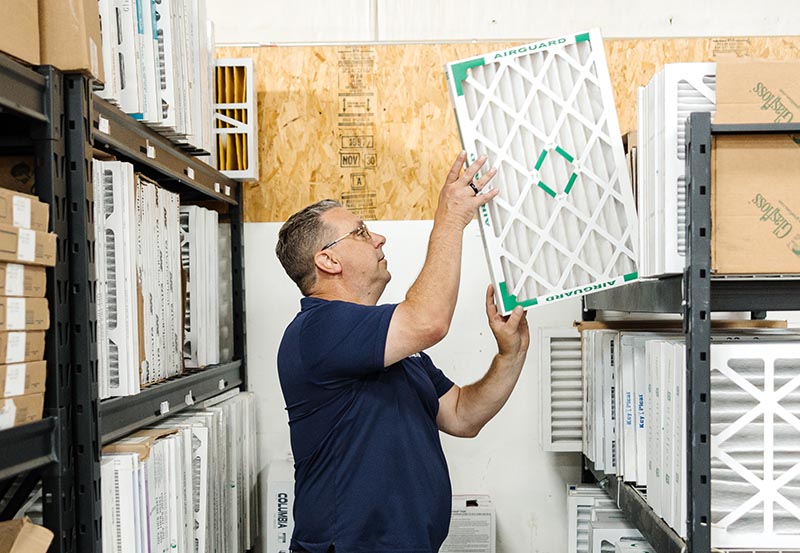 Lifetime technician pulling filter from shelving.