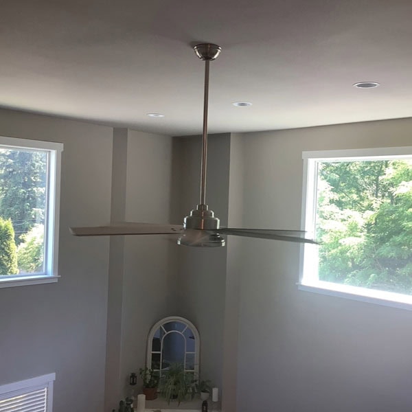 Residential ceiling fan in lofted ceiling room.