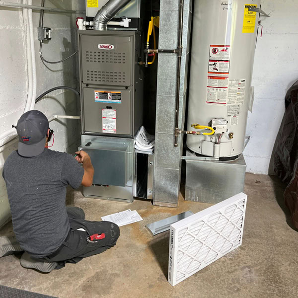 Lifetime Heating, Cooling, Plumbing & Electric technician working on residential furnace.