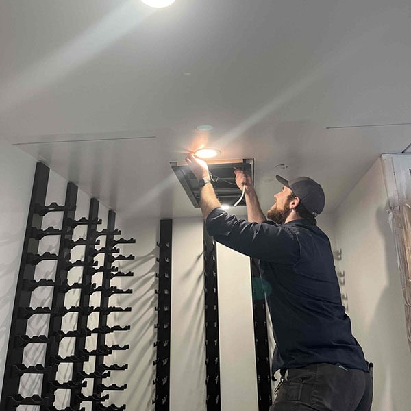 Lifetime Heating, Cooling, Plumbing & Electric technician working on residential recessed lights.