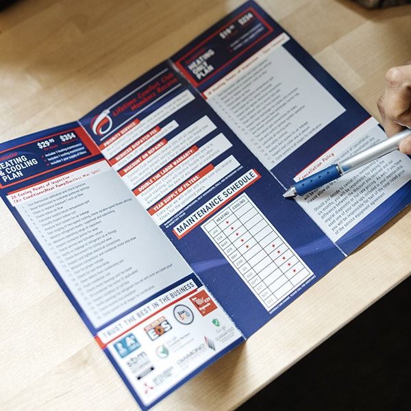 Lifetime Heating, Cooling, Plumbing & Electric maintenance brochure on desk.